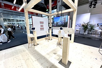 Foto von einem Messestand von STRABAG. Mit Blick auf eine Ecke mit I-Pads.  