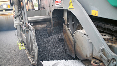Bild von einer Straße bei der abgetragener Asphalt wiederverwendet wird