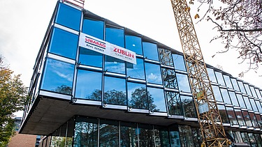 Foto von einem glasigen Bürogebäude. 