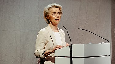 Foto von Ursula von der Leyen die eine Rede hält. 