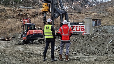 Zwei Personen schauen auf eine Baustelle