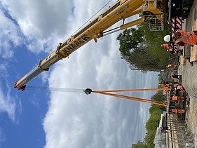Foto von einer Baustelle mit mehren Personen in Schutzausrüstung. 