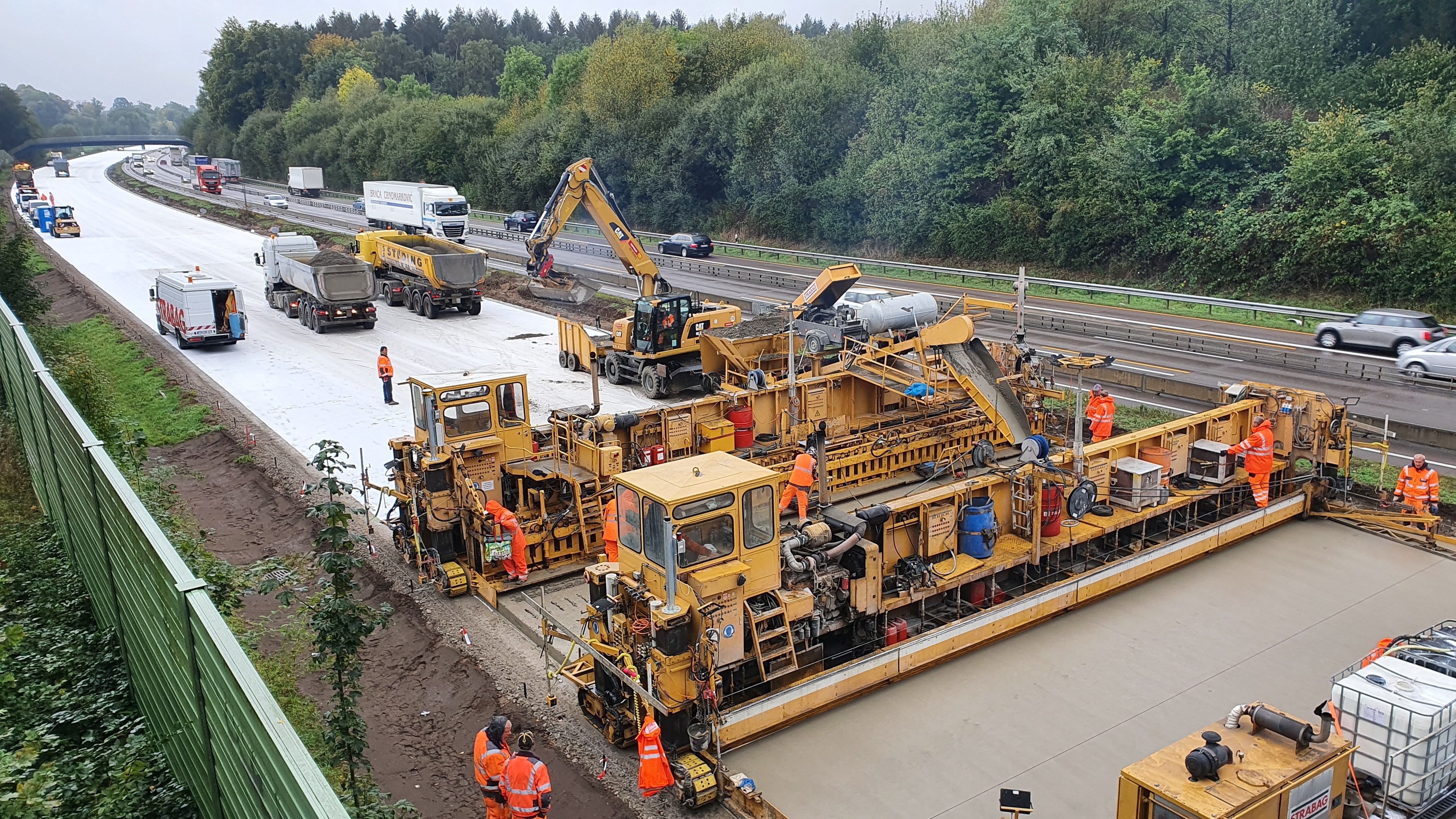 Das Bild zeigt eine große Betonbaustraßenmaschine beim Einsatz