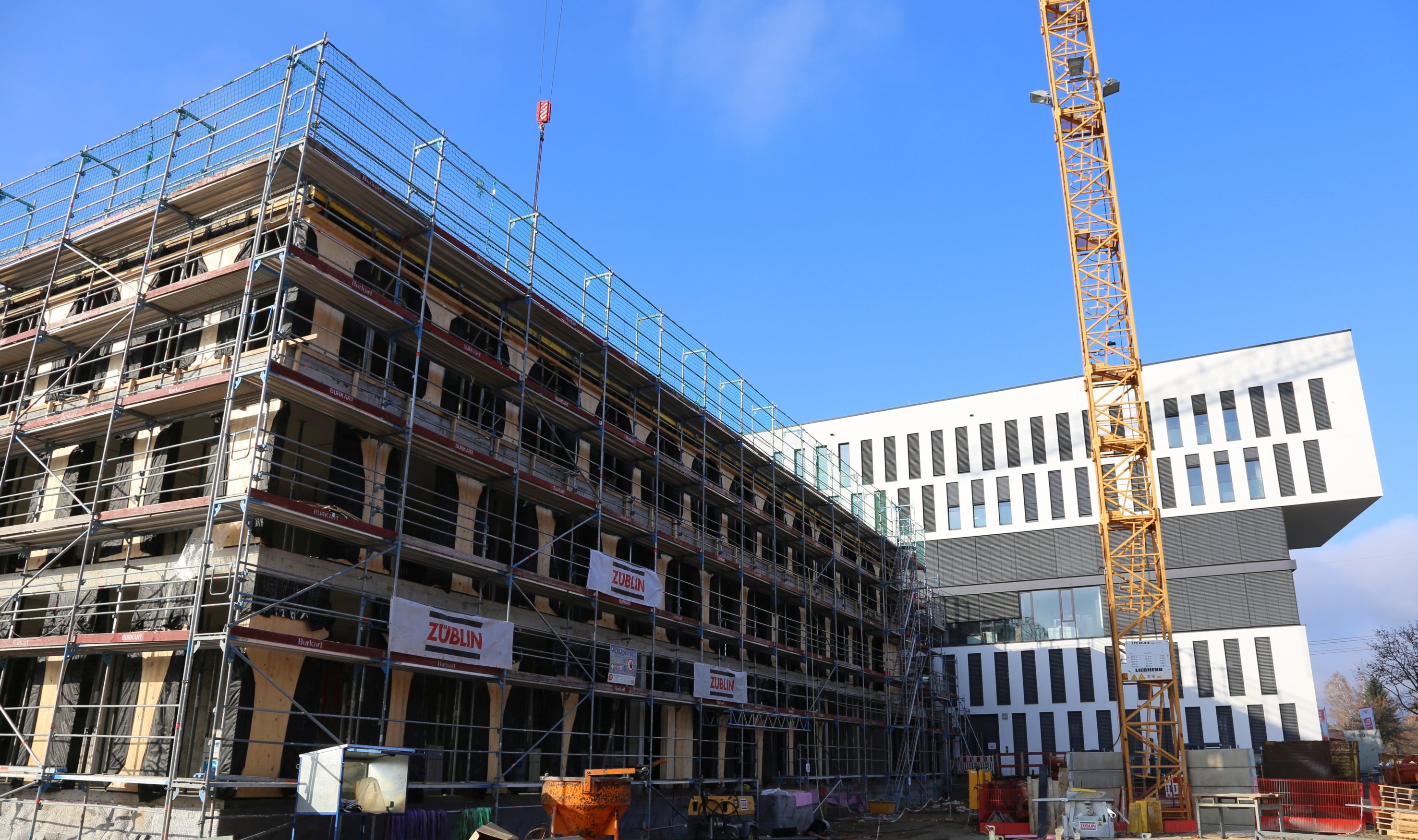 Foto vom Bau eines Hauses. An der Seite ist ein Karan zusehen. 