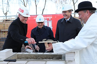 Foto von vier Männern bei der Grundsteinlegung für die Erweiterungsbau der Techniker Krankenkasse in Hamburg.