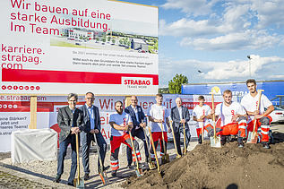 Das Foto zeigt mehrere Personen mit Schaufeln hinter einem Erdhaufen