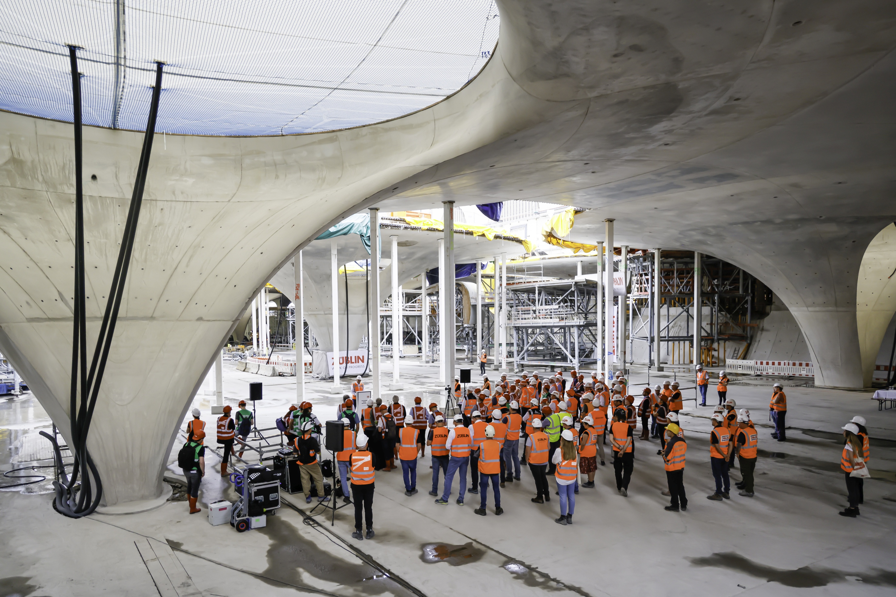 Foto von mehreren Personen in Schutzausrüstung auf einer Baustelle.   