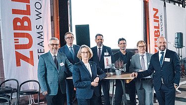Foto von mehreren glücklich schauenden Personen bei der Jubiläumsfeier am Standort Sande.