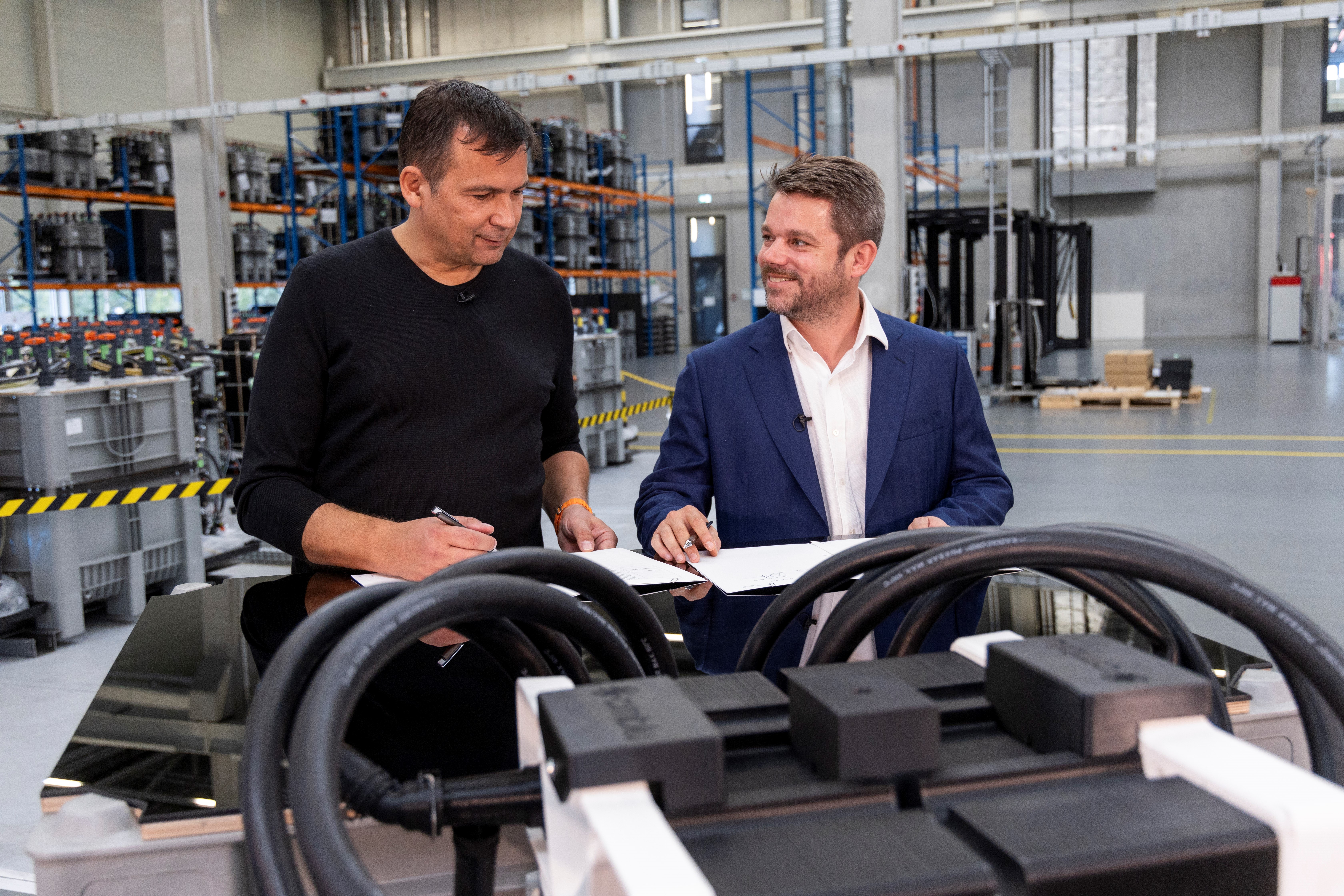 Photo of two people standing behind a workbench on which batteries are placed