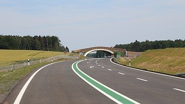 Foto einer leeren Fahrbahn, die in einer Unterflurtrasse mündet