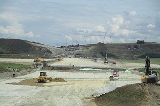 Photo shows a highway construction site with several machines at work
