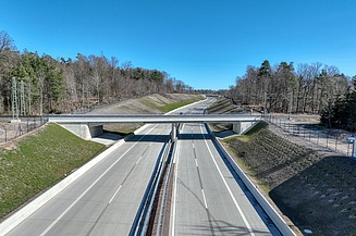Bahnbrücke, die über eine Autobahn führt