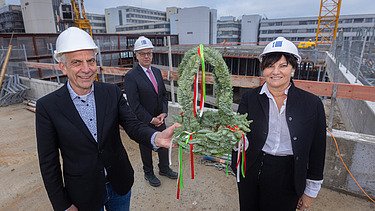 Foto von mehreren Personen beim Halten des Richtkranzes. 