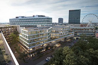 Das Bild zeigt ein Bürogebäude in einer Luftaufnahme, im Hintergrund weitere Gebäude und ein Riesenrad