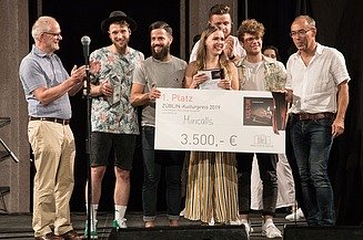 Foto von freudig Schauenden Personen auf einer Bühne, die den 1. Platz des ZÜBLIN-Kulturpreis 2019 in der Hand halten.  