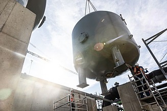 Foto von einem schweren Kessel, der in die Höhe gehoben wird mit einem Kran