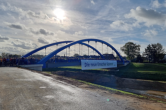 Foto von einer Brücke über einen Fluss, der Himmel ist leicht bewölkt