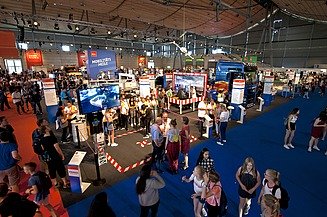 Foto einer Messehalle von innen mit vielen Personen an Messeständen