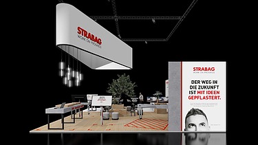 Foto eines modernen Messestands mit Roll-up rechts, Bestuhlung und Tischen, der Hintergrund ist schwarz