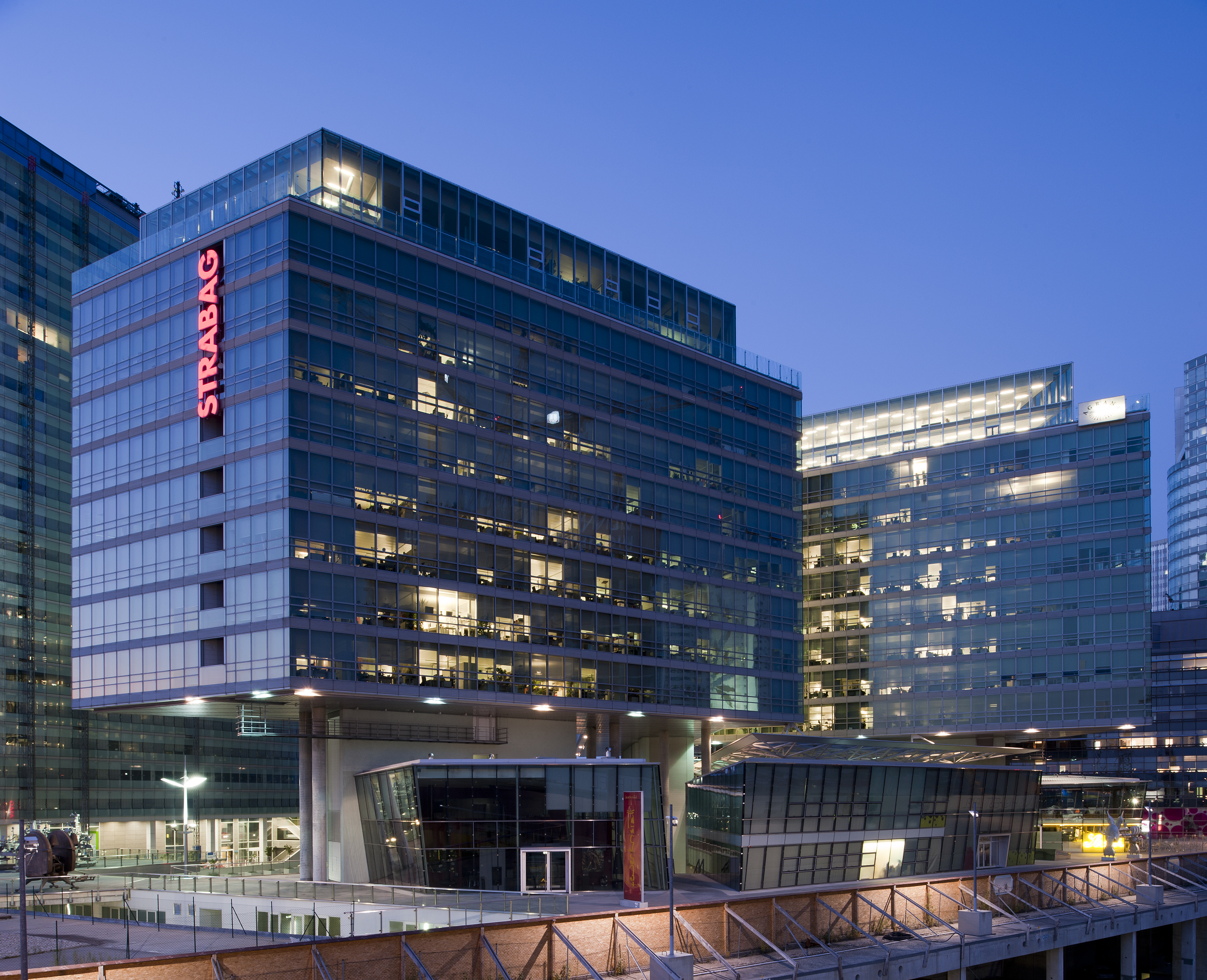 The illuminated STRABAG office can be seen at dusk in Vienna. 