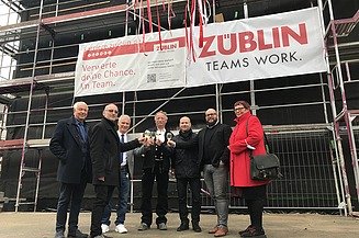 Foto von mehren Personen beim Anstoßen nach dem Richtstoß. 