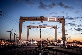 Foto eines Portalkrans auf einer Straße bei dämmernder Lichtstimmung