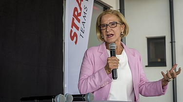 Governor Johanna Mikl-Leitner in front of a STRABAG flag