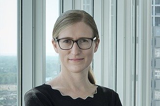 Foto von Marianne Jakl, die vor einem Fenster steht