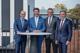 Foto von vier Personen, die an einem Stehtisch stehen