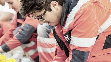 The picture shows two people in work clothes at work