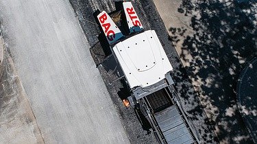 Maschine, die Asphalt verlegt aus Vogelperspektive