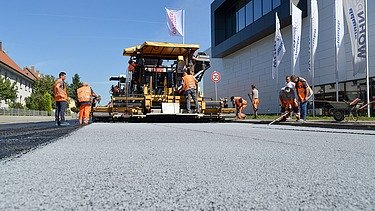 Foto von einer Asphaltiermaschine bei der Arbeit