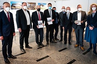 Foto von mehreren, stehenden Personen, die Coronamasken tragen