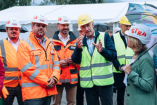 Foto von mehreren Personen, die Bauhelme und Schutzjacken tragen