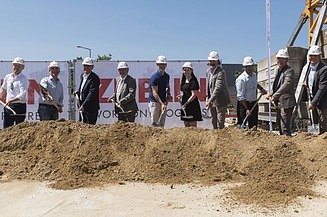 Photo of several people in suits at the laying of the foundation stone.