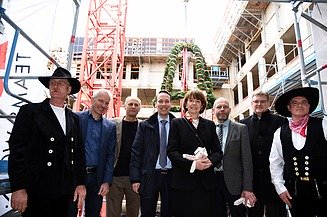 Foto mit der Oberbürgermeisterin von Köln auf der Baustelle im Antoniter Quartier in Köln. Um sie herum sind glück schauende Männer. 